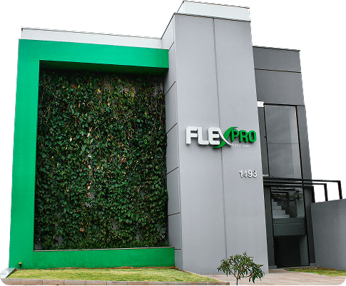 Fachada da sede da Flexpro Sistemas com logo da empresa em prédio moderno com parede verde vertical e identidade visual em verde.
